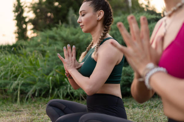 istock Women Practising Yoga at Park 1169915214