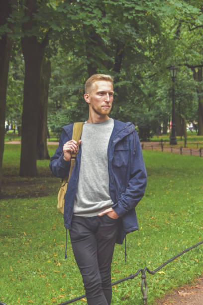 istock young man with a beard in a Park among the trees 1169921324