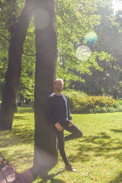 istock young man with a beard in a Park among the trees 1169921538