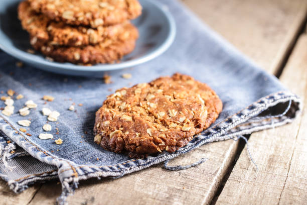 galletas anzac caseras. galletas tradicionales australianas de avena y coco - nobody cookie oat close up fotografías e imágenes de stock