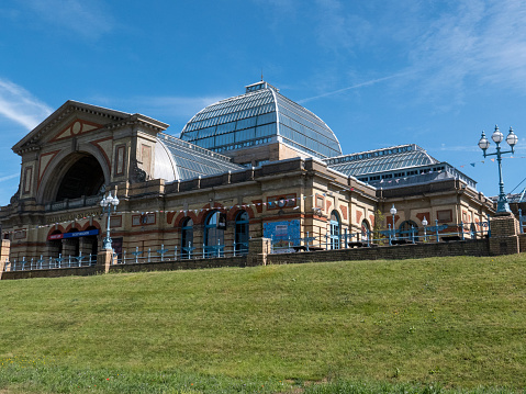 1st June 2019: Exterior of Alexandra Palace, affectionately known as Ally Pally. It was originally built by John Johnson and Alfred Meeson, and opened in 1873. Following a fire two weeks after opening it was built again by Johnson, with the intention of being the people's palace, to be used for events, entertainment and education. In 1936 it became home to the BBC and was the first site of its television broadcasting. Located in Muswell Hill, north London, today it is a Grade II listed building still being used as a venue for events and recreation, preserved with surrounding public park land.