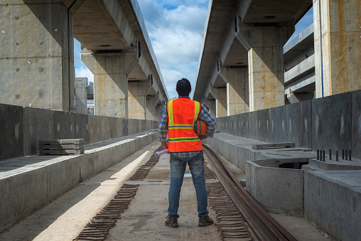 Senior engineer looking drawing on site construction of mass transits