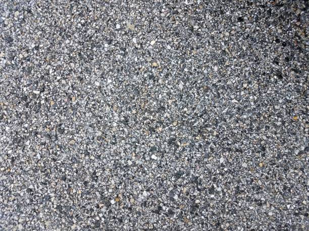 istock black, white, and grey stones or rocks on asphalt 1169927756