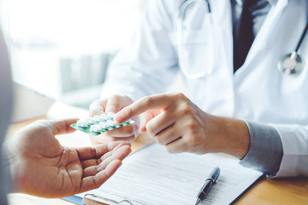 Doctor or physician recommend pills medical prescription to male Patient  hospital and medicine concept Doctor or physician recommend pills medical prescription to male Patient  hospital and medicine concept prescription medicine photos stock pictures, royalty-free photos & images