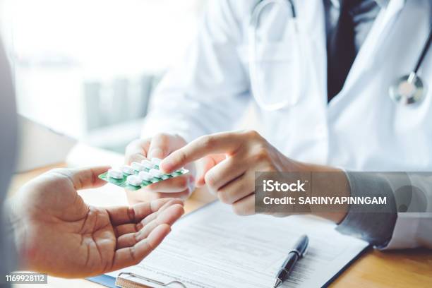 Doctor Or Physician Recommend Pills Medical Prescription To Male Patient Hospital And Medicine Concept Stock Photo - Download Image Now