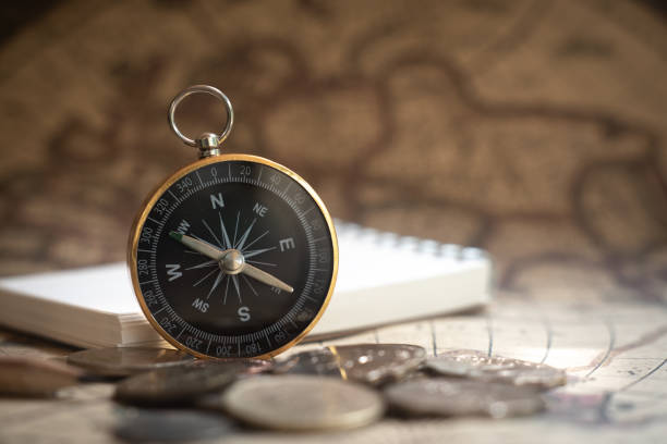 istock Compass on old vintage brown map background, journey planning concept, copy space 1169929034
