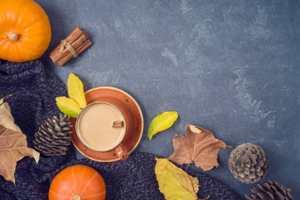 istock Autumn concept with coffee cup, pumpkin and fall leaves over blackboard background. Top view from above 1169931898