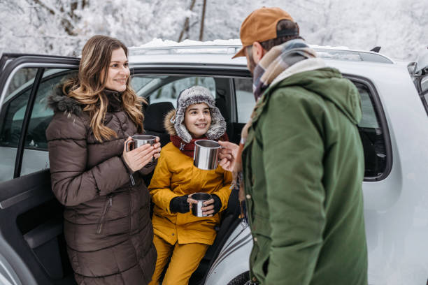 istock Family drinking tea outdoors on a winter road trip 1169932072