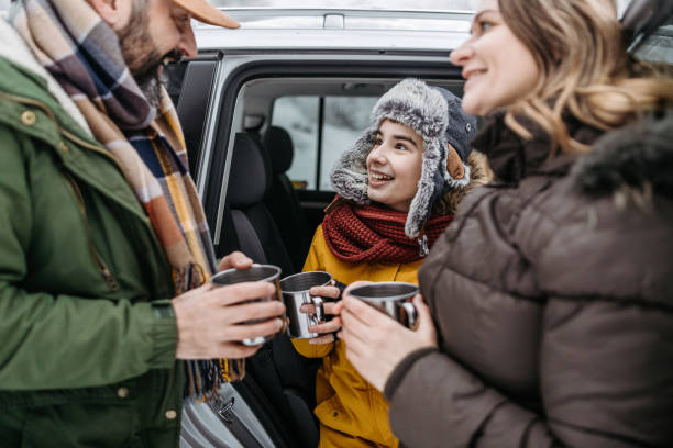 istock Family drinking tea outdoors on a winter road trip 1169932089