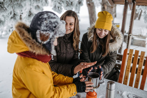 istock Family drinking tea outdoors at winter time 1169932269