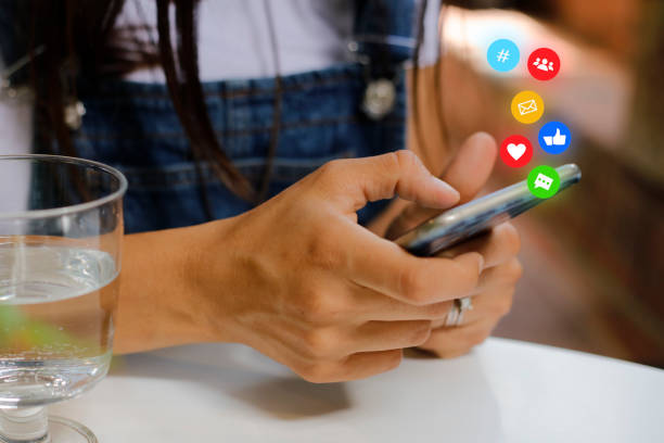 mano de mujer usando el teléfono móvil con icono de las redes sociales y la red social. concepto de marketing online - connection e mail typing human hand fotografías e imágenes de stock