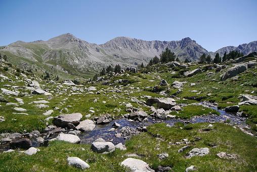Rocky, mountainous landscape of the Pyrenees, Andorra, in the middle of summer with a clear blue sky and alpine vegetations.