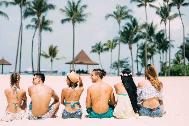 istock Group of friends sitting on beach 1169939522