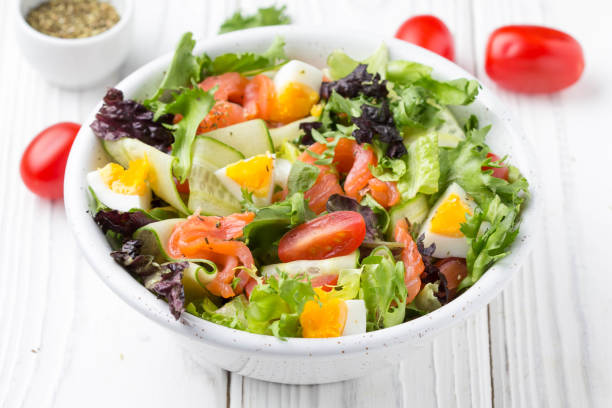 Salad with salmon, egg and vegetables (cherry tomatoes, cucumber, lettuce), delicious light lunch, healthy food stock photo
