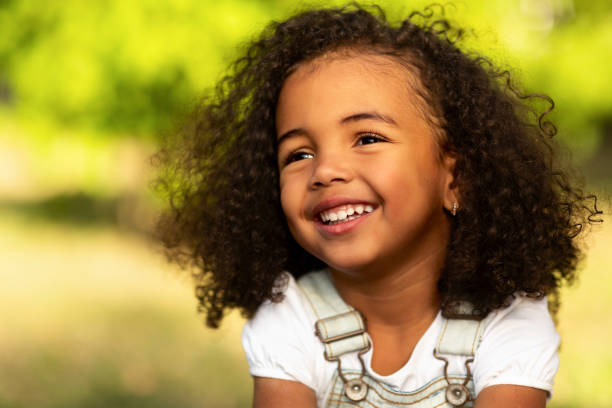 istock Cute afro girl smiling broadly outdoors, having picnic with parents 1169949965