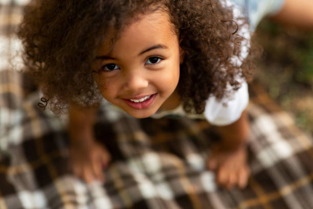 毛布の上で遊んで見上げるかわいい女の子 - child little girls smiling autumn ストックフォトと画像