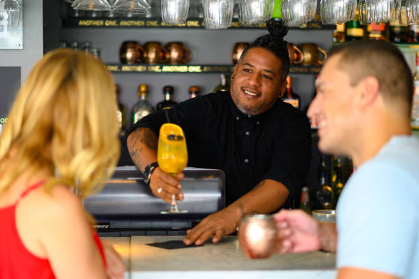 istock Confident bartender serving cocktail to couple 1169950029