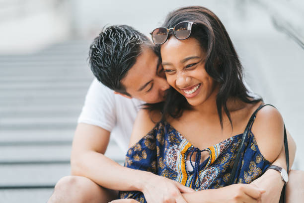 istock Young multi-ethnic couple sitting at steps and embracing each other 1169953032