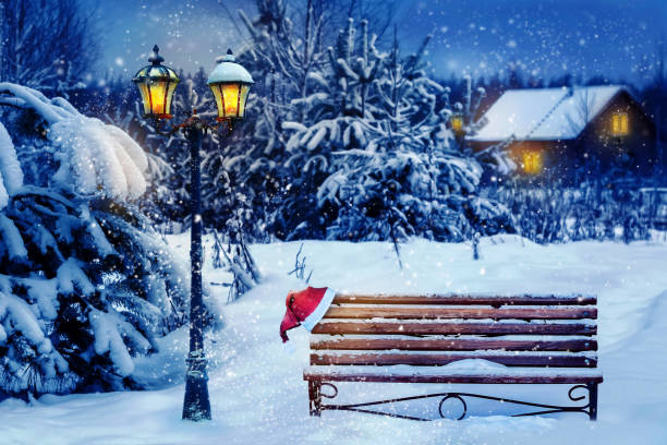 christmas art card. santa hat on a bench in the snow against the background of the christmas winter forest. village house in the background. wonderland. - snow winter bench park imagens e fotografias de stock