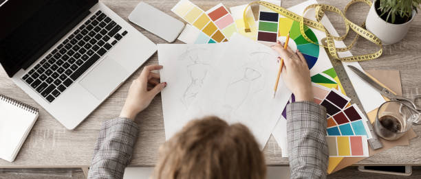 istock Dressmaker drawing sketches, designing new collection. top view 1169953229