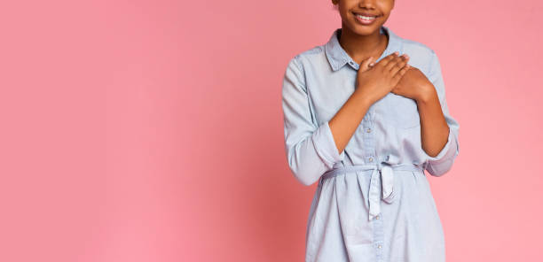 Grateful african girl pressing hands to chest