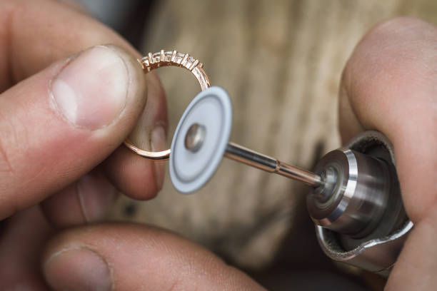 Polishing a gold ring in a jewelry workshop. Workflow close up. The master is engaged in processing the product Polishing a gold ring in a jewelry workshop. Workflow close up. The master is engaged in processing the product Polishing Jewelry stock pictures, royalty-free photos & images