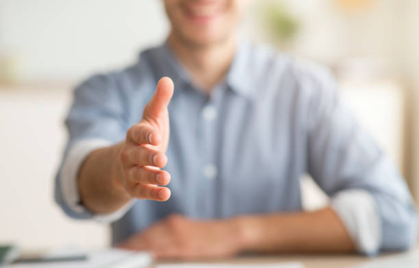 istock Unrecognizable Young Man Stretching Hand For Handshake Greeting At Home 1169954309