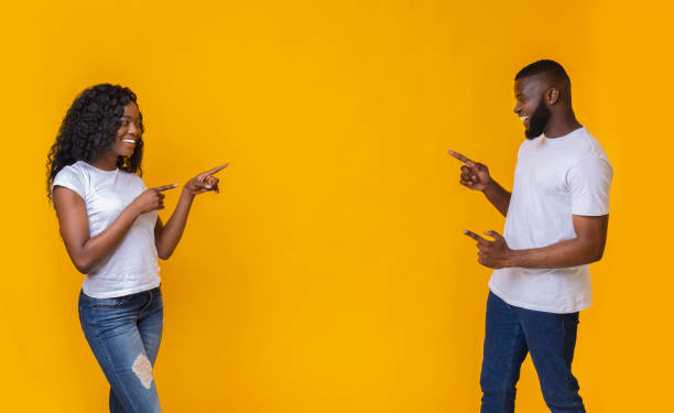 istock African american man and woman pointing at empty space 1169956104