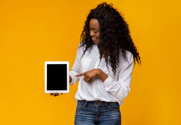 istock Black woman pointing at blank digital tablet screen 1169956203