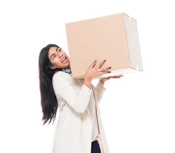 istock Attractive young latino female is holding a box 1169956395