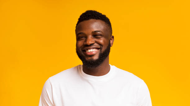 istock Cute carefree black guy laughing on yellow studio background 1169956687