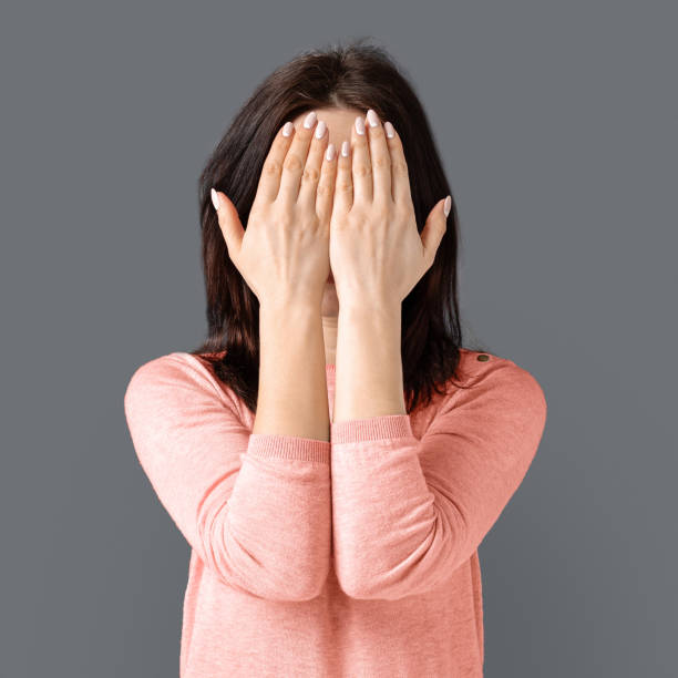 istock Young caucasian woman hiding her face from camera 1169956771