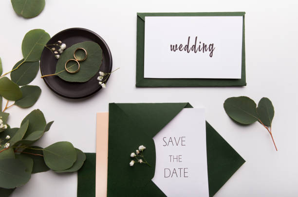 istock Stylish wedding invitations and golden rings on white 1169956809
