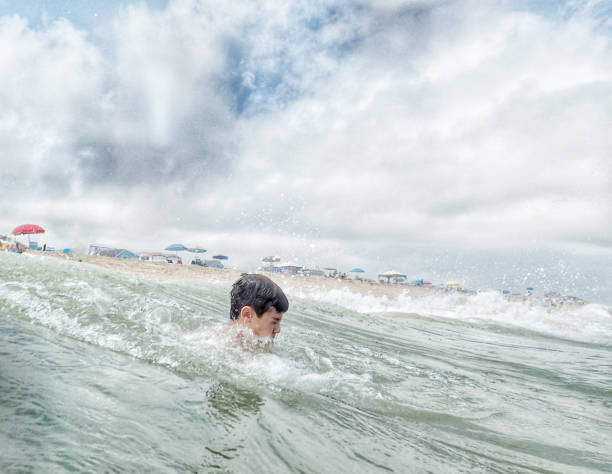 Boy emerging from a breaking wave in South Bethany Beach Delaware