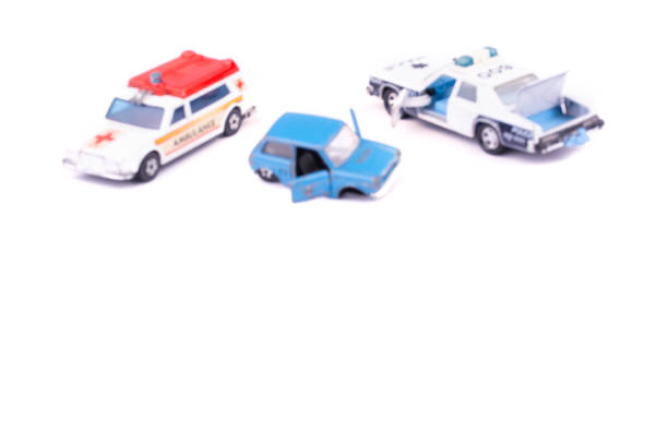 istock Blurred image smashed up and broken from accident or malfunction childrens toy car isolated on white background with ambulance and police on crash site helping concept of road safety and insurance 1169961317