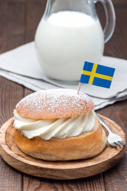 istock Traditional swedish dessert Semla, also called Shrove bun, with almond paste and whipped cream filling, served with milk, vertical 1169962912