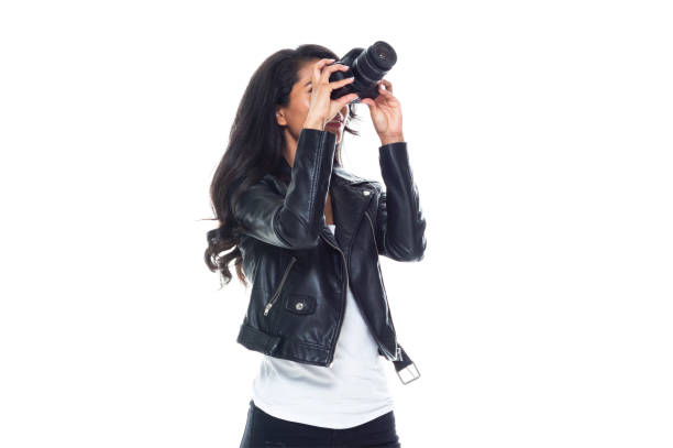 istock Bautiful woman wearing a leather jacket sitting and using a DSLR camera 1169963229