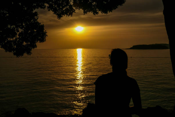istock Vrsar - A girl enjoying the sunset by the beach 1169968285
