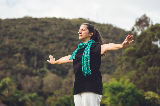 Woman meditating with arms raised