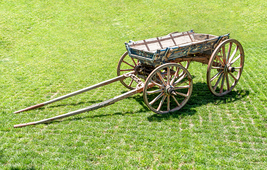 Close up on an old antique wagon. Turkish horse drawn vehicle on green grass.