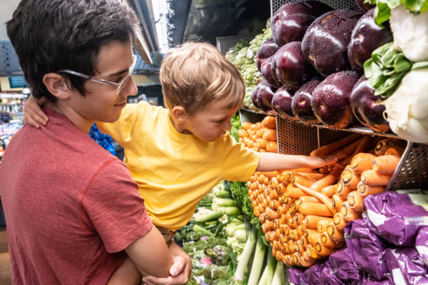 istock Young man shopping for vegetables with is child son 1169972291