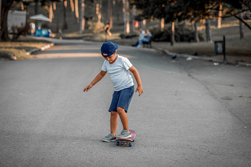 Kid skateboarder.Skater boy child with his skateboard. Outdoor activity.