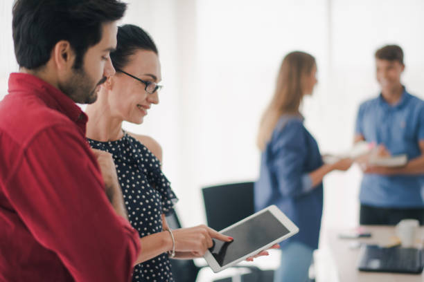 istock Group of young creative people are standing, working and brainstorm which looking at tablet. Team of creative co-workers planning the work. felling be happy. Co working space concept. 1169976930