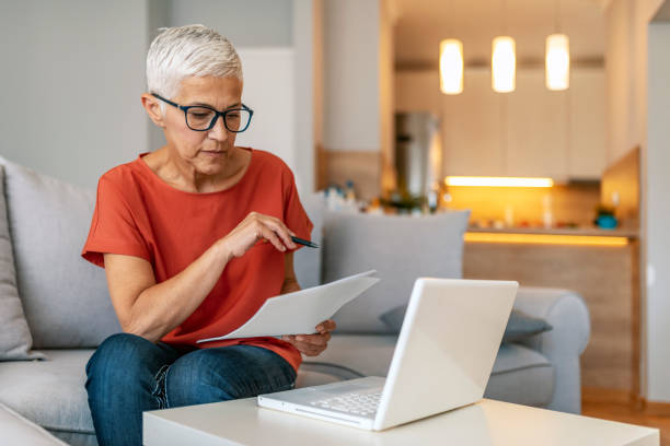 istock Worried senior woman using laptop 1169976961