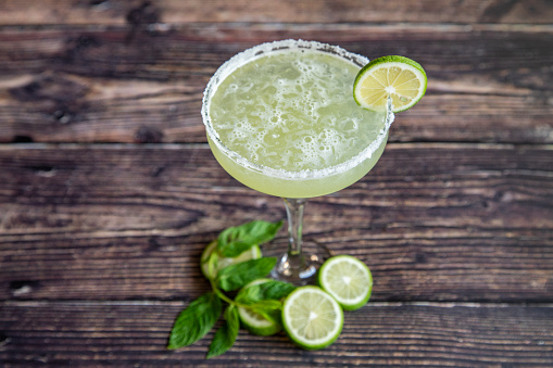 Margarita cocktail  with lemon slices and mint leaf.
