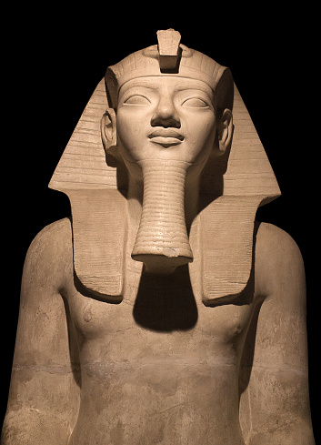 Detail of sitting Egyptian Pharaoh Statue isolated on black background