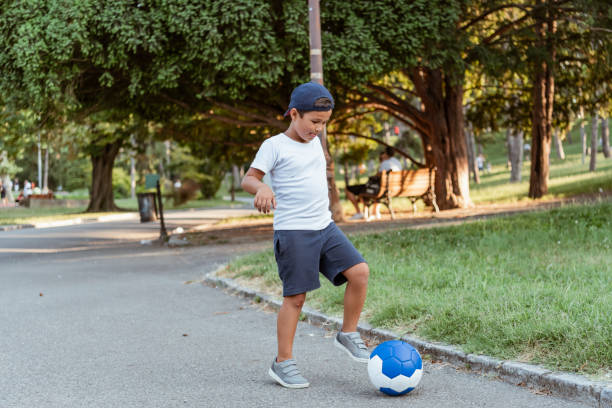 istock Boy play with football ball 1169980267