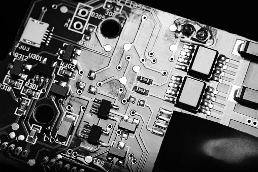 A close-up microchip with many electrical components placed on the Board. The background is blurred.