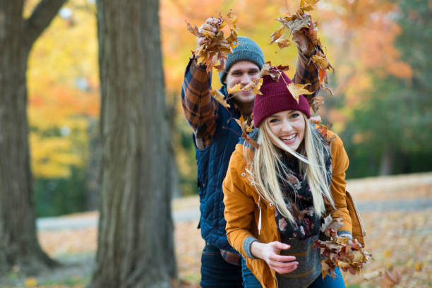 playing in the leaves - nature forest clothing smiling imagens e fotografias de stock