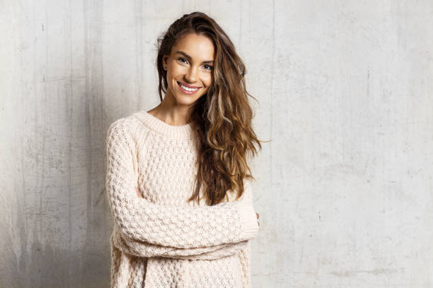 Smiling pretty girl in knitted sweater in studio